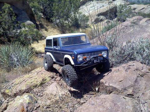 1988 Ford Bronco - RC crawler resembling a 1978 Ford Bronco navigating a rocky, outdoor course.