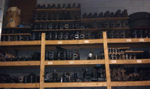 1990 Ford Bronco - Storage shelves are packed with numerous engine components, likely for automotive repair or resale.