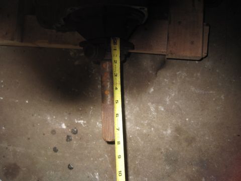 1979 Ford Bronco - A driveshaft is measured with a tape measure, showing a portion of a vehicle's transmission assembly.