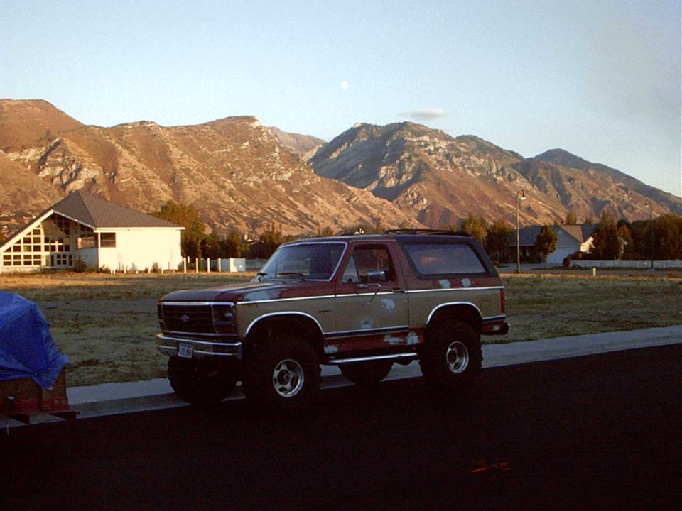 Ford Bronco parked on a street with mountains in the background