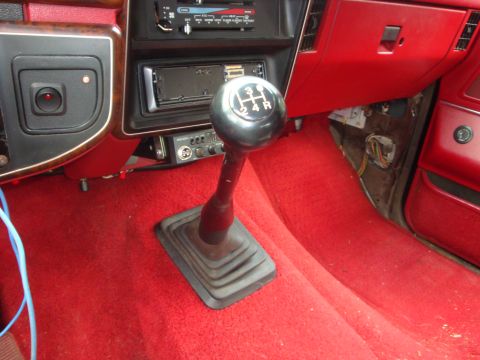 1989 Ford Bronco - Interior view of a 1989 Ford Bronco, highlighting the manual shifter and red carpeting.