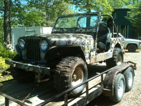 1992 Jeep YJ - This Jeep CJ, possibly a CJ-7, is loaded onto a trailer with a camouflage paint scheme.