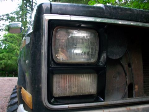1983 Chevrolet C/K Pickup - Close-up of the front corner of a 1983 Chevrolet C/K Pickup, showing the headlight assembly.