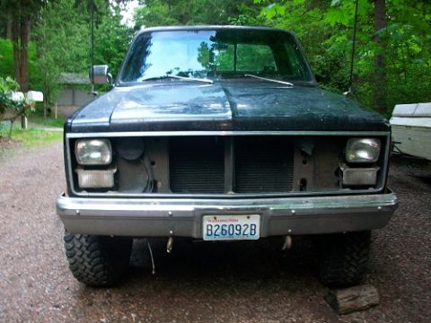 1983 Chevrolet C/K Pickup - Front view of a 1983 Chevrolet C/K Pickup with a missing grille and aftermarket tires.