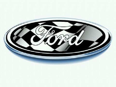 1998 Ford Crown Victoria - A Ford oval badge with a black-and-white checkered flag pattern filling the oval behind the chrome script lettering, shot straight on again…