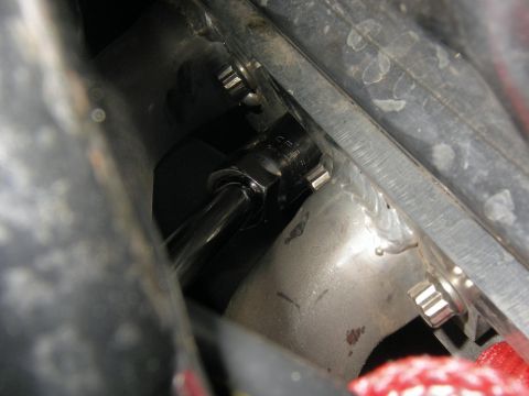 1990 Ford Bronco - A close-up view of a socket wrench engaging with a bolt on a metallic component.