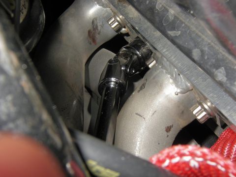 1990 Ford Bronco - Close-up of a socket wrench attached to an engine part, likely during maintenance.
