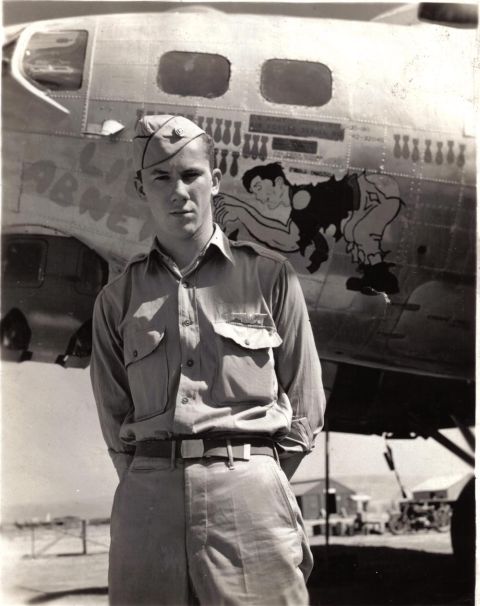 2000 Ford Crown Victoria - Airman poses in front of a B-17 bomber aircraft, likely during WWII.