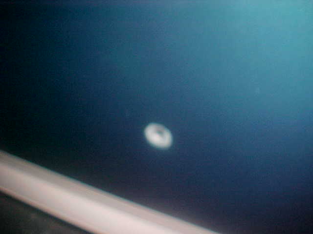 Blurry close-up of dark blue painted panel with a small white circular mark and a white trim strip below