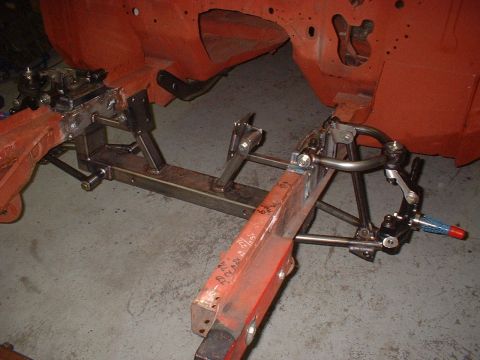 1964 Ford Fairlane - A close-up view of a custom front suspension system being assembled, showing fabricated metal components and suspension arms.