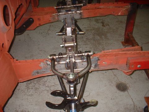 1964 Ford Fairlane - Close-up of a car's front suspension system, showing the chassis and various metal parts.