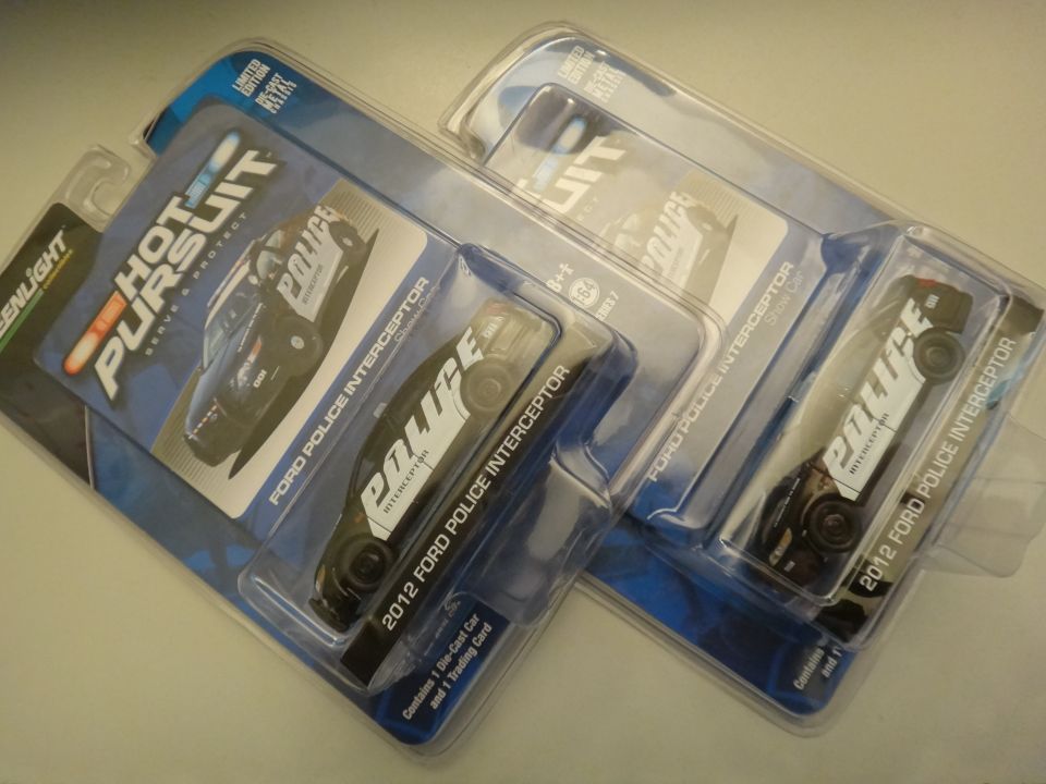 Three Greenlight Hot Pursuit toy police car models in packaging, labeled 2012 Ford Police Interceptor