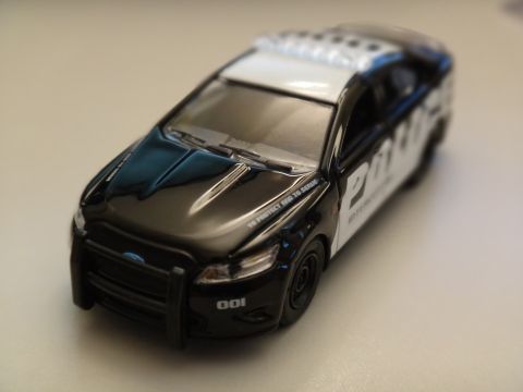 1993 Ford Taurus - A toy police car is shown from a 3/4 front angle.