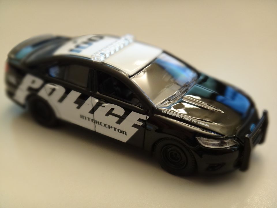 Black toy police car with 'POLICE INTERCEPTOR' text and light bar