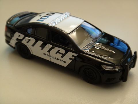1993 Ford Taurus - A black police car with "POLICE INTERCEPTOR" text and a light bar is shown from a three-quarter front angle.