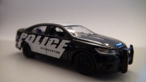 1993 Ford Taurus - Toy police car model with push bar and light bar.