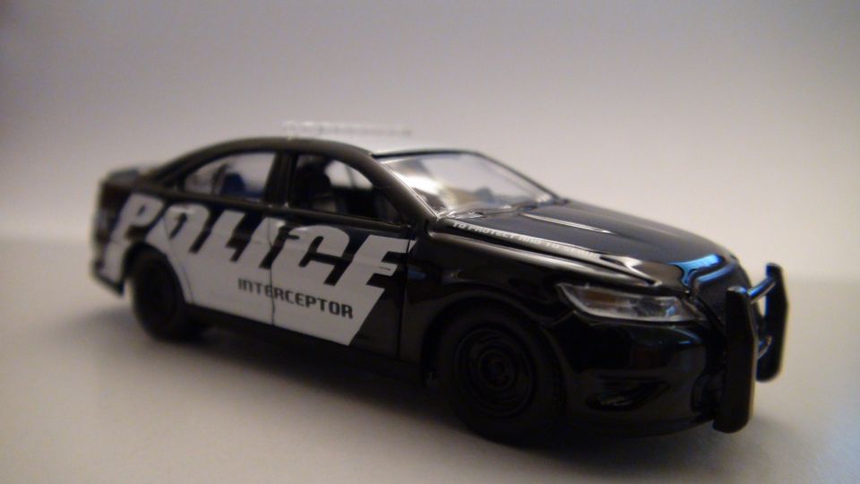 Black toy police car with 'POLICE INTERCEPTOR' text on the side