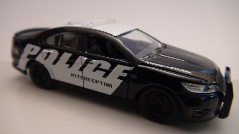 1993 Ford Taurus - A close-up view of a toy police car, detailed with 'POLICE' and 'INTERCEPTOR' markings.