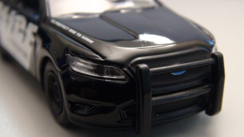 1993 Ford Taurus - A close-up view of the front of a black police car, a push bar and text on the hood.