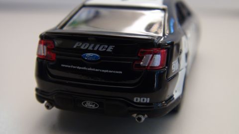 1993 Ford Taurus - Rear view of a black Ford Police Interceptor Utility model, displaying 'POLICE' and a website address.