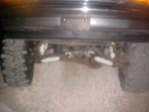 1996 Ford Bronco - The rear axle and large tires of an off-road vehicle are visible in this close-up shot.