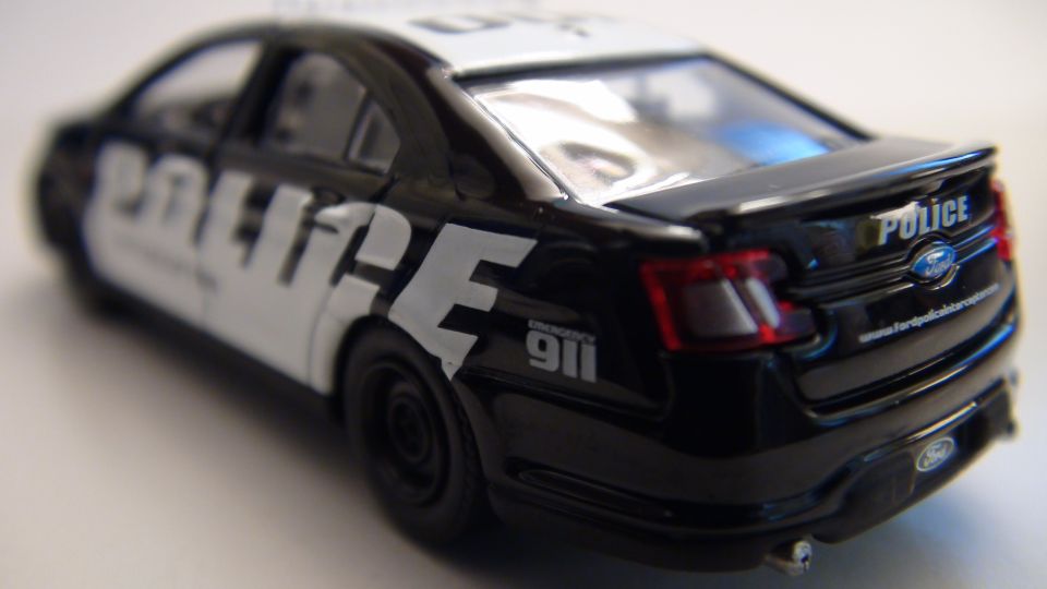 Black toy police car with 'POLICE' text on the side and rear
