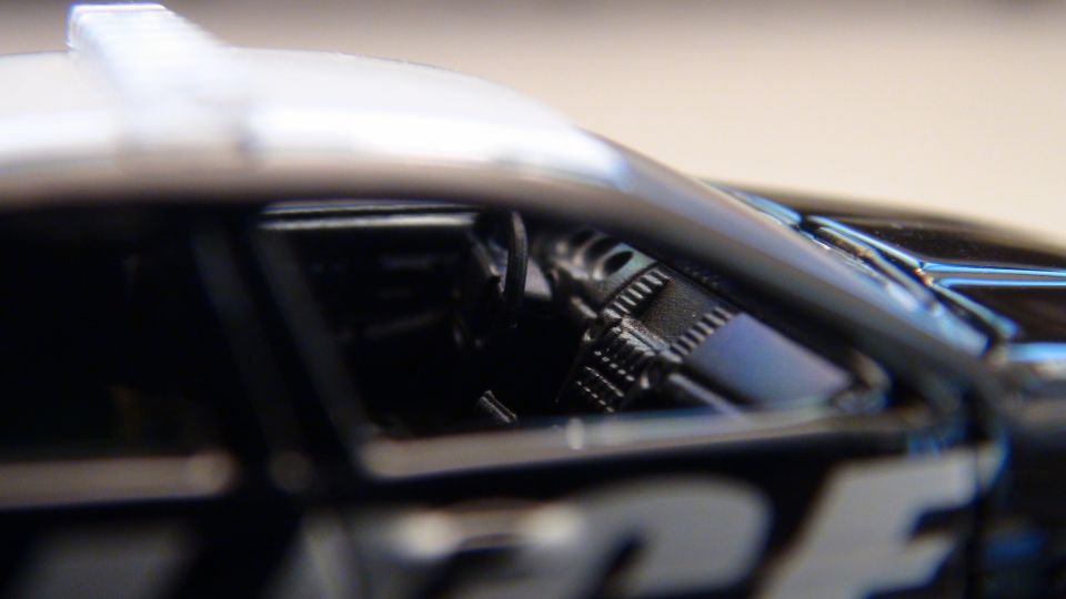 Black and white police car interior with visible steering wheel and dashboard details