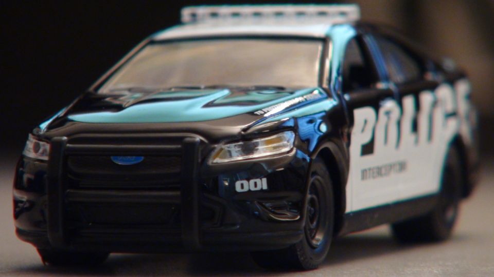 Black toy police car with 'POLICE INTERCEPTOR' text and '001' marking