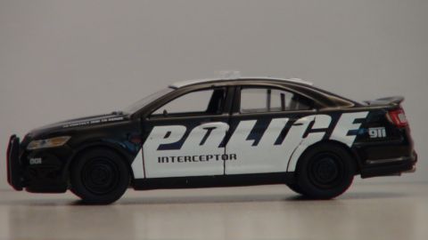 1993 Ford Taurus - Side view of a toy police car model with 'POLICE INTERCEPTOR' markings.