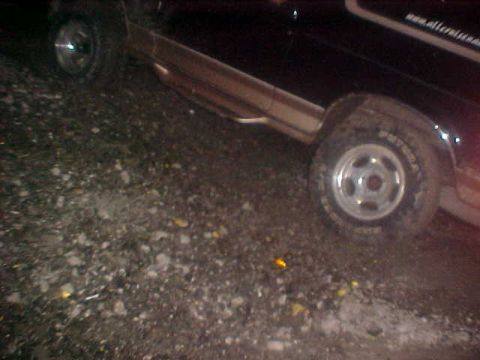 1996 Ford Bronco - A 1996 Ford Bronco is parked on a gravel surface, showing its side profile.