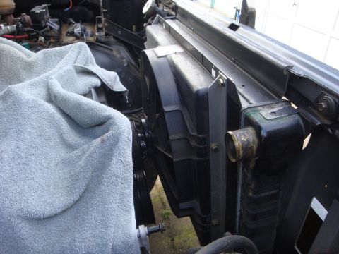1989 Ford Bronco - Close-up of a vehicle's radiator and fan assembly, partially covered by a towel.