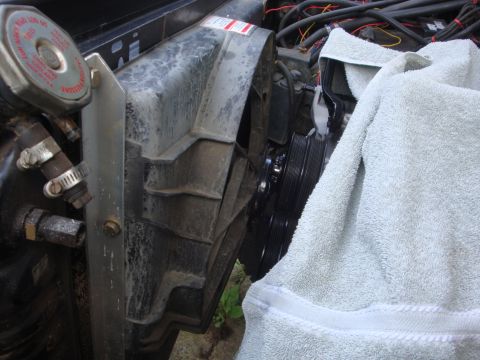 1989 Ford Bronco - Close-up view of engine bay components including the radiator fan shroud and coolant reservoir cap.