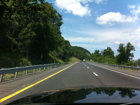 1999 Ford Crown Victoria - View from a car driving on a highway on a sunny day with clouds.