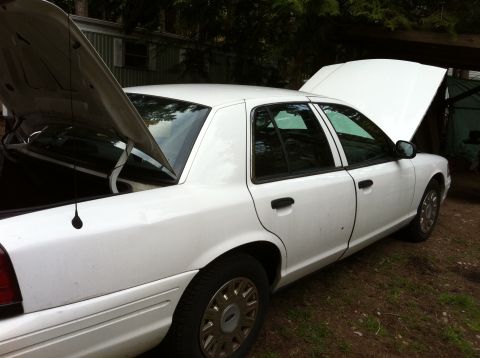 2005 Ford Crown Victoria - White 2005 Ford Crown Victoria has both hoods open, parked in a grassy area.