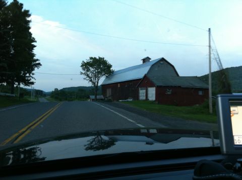 1999 Ford Crown Victoria - A scenic drive through the countryside features a classic red barn alongside the road.