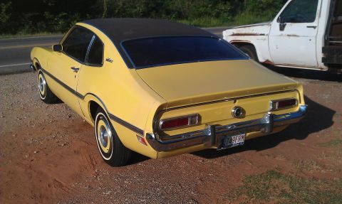 1965 Ford Mustang - Rear view of a yellow 1970 Ford Maverick with a black vinyl top.