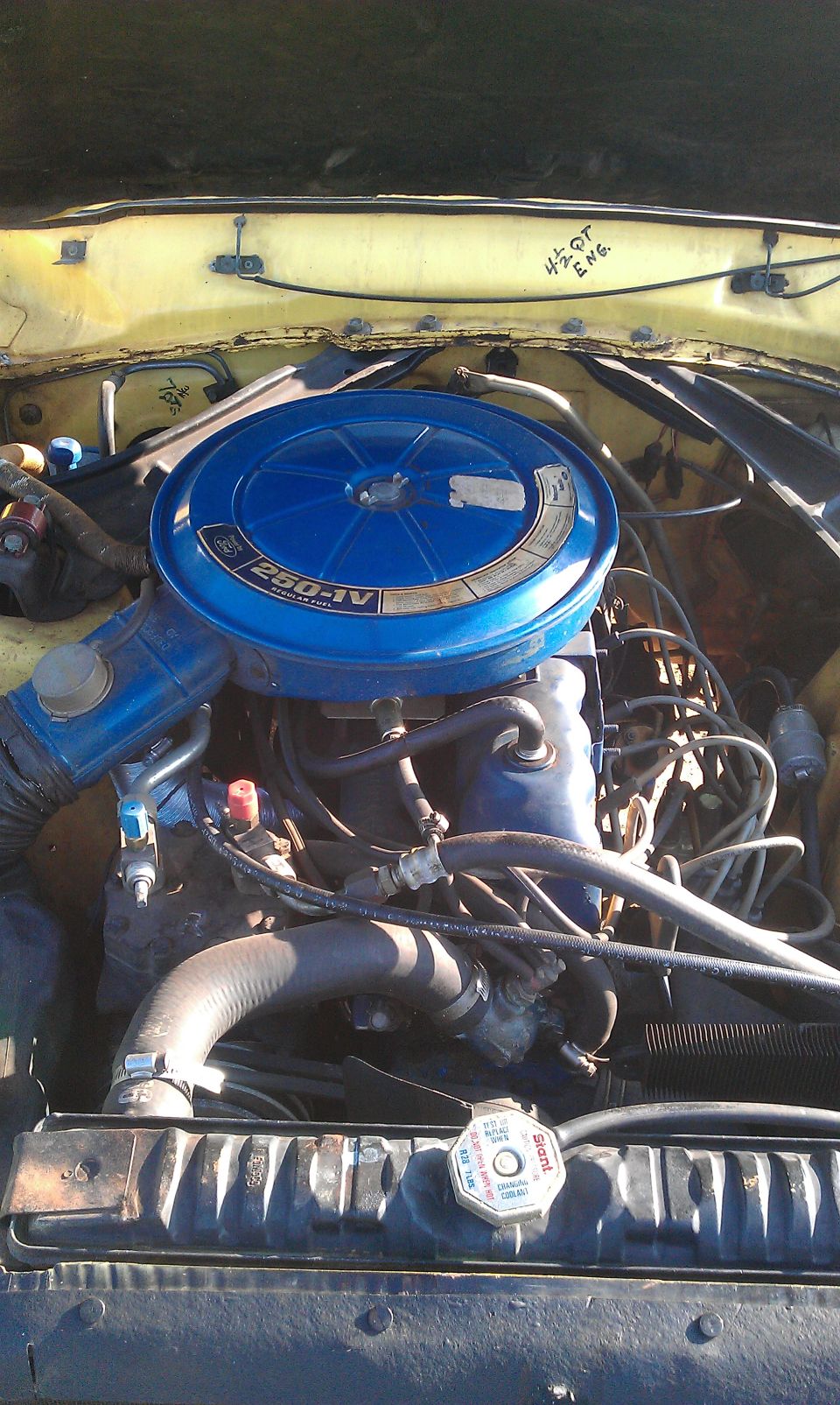 Engine bay with blue air cleaner labeled 250-IV. Handwritten text '4.2L DT ENG' visible