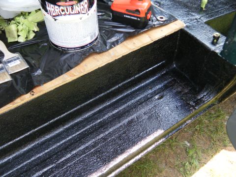 1981 Ford E350 - Applying Herculiner truck bed liner to a wooden frame with brushes and tools nearby.