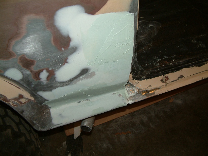 car body panel being repaired with body filler and primer