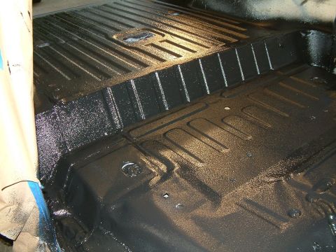 1983 Ford Bronco - Applying undercoating to the floor pan of a vehicle.