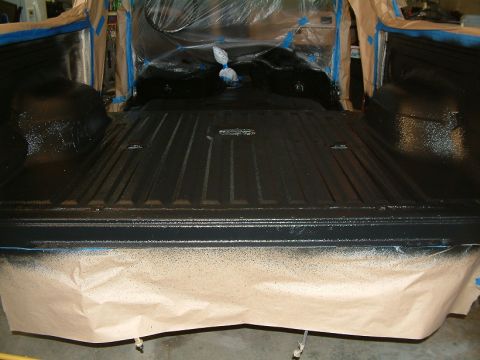 1983 Ford Bronco - The truck bed is being painted black, with protective paper covering the tailgate area.