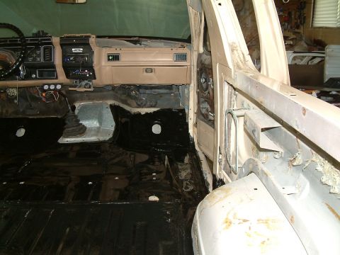 1983 Ford Bronco - Interior view of a vehicle undergoing restoration, showing exposed metal and a tan dashboard.