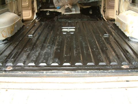 1983 Ford Bronco - The interior floor of a vehicle has been coated with a black protective material.