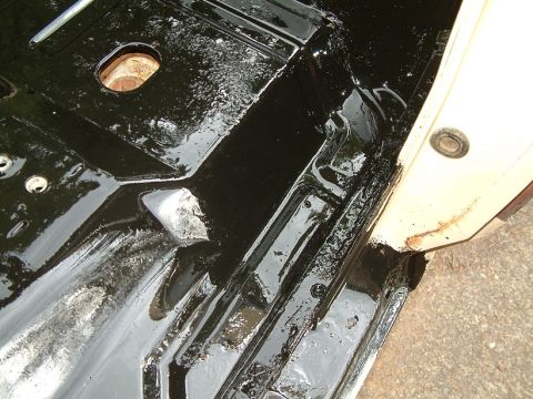 1983 Ford Bronco - Undercarriage of a vehicle shows black undercoating and signs of rust.