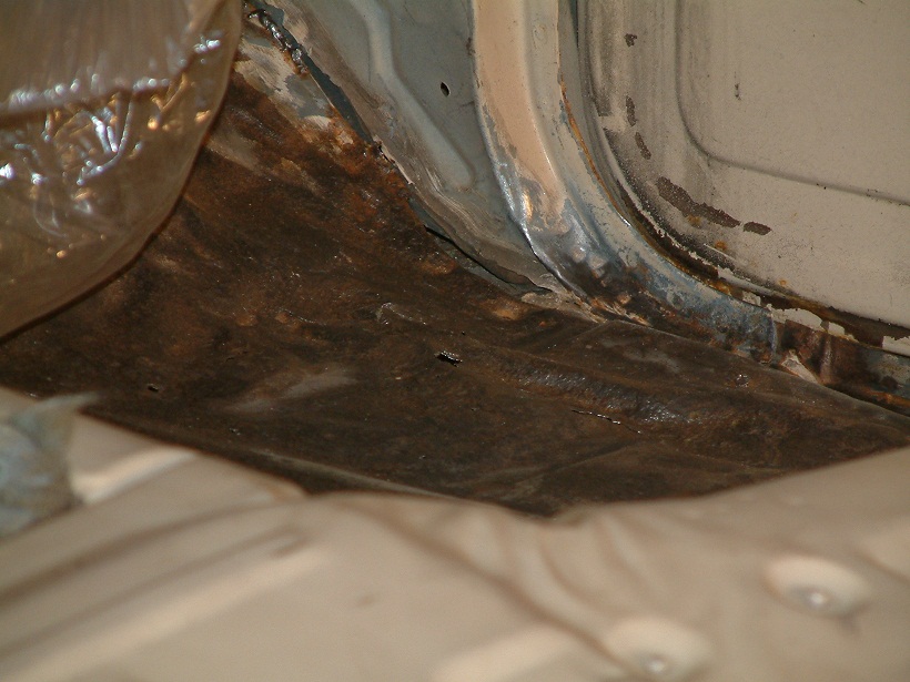 Rusted floor pan and rocker panel interior view