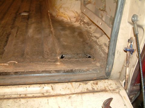 1983 Ford Bronco - The interior of a vehicle's cargo area shows significant rust and damage, with a watermark for Supermotors.net.