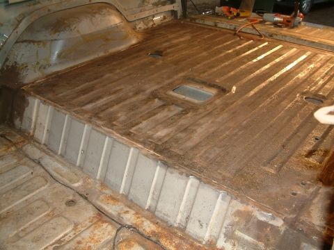 1983 Ford Bronco - Vehicle interior floor stripped down to bare metal, showing signs of rust and previous repairs.