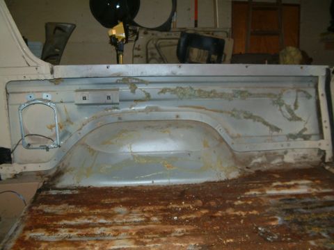 1983 Ford Bronco - Heavily rusted interior of a truck bed, including the wheel well and floor panels.