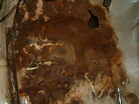 1983 Ford Bronco - This heavily rusted floor pan shows significant damage and corrosion.