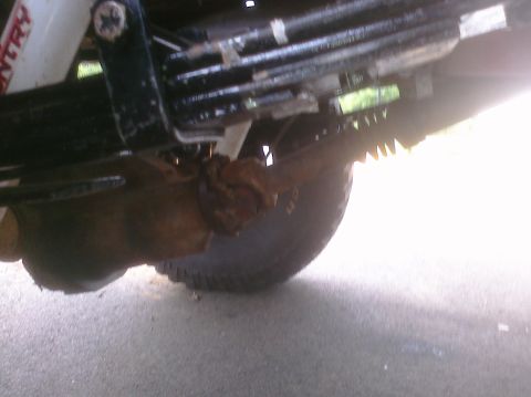 1995 Ford Bronco - Underside view of a vehicle's suspension system, showing the leaf spring and tire.